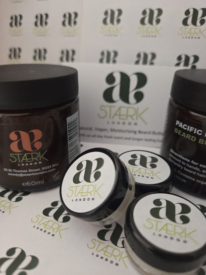 Four jars of Beard Butte by Stark London, including two larger dark brown jars and two smaller white jars with black lids, arranged on a branded white background with repeated Stark London logos.